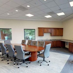 Conference room with grey chairs surrounded an oval table