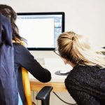 Two women looking at a computer screen